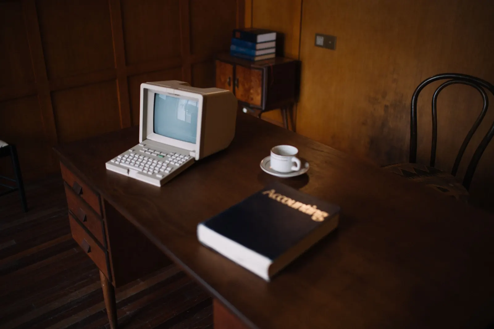 Computadora retro sobre un escritorio de madera con luz cálida