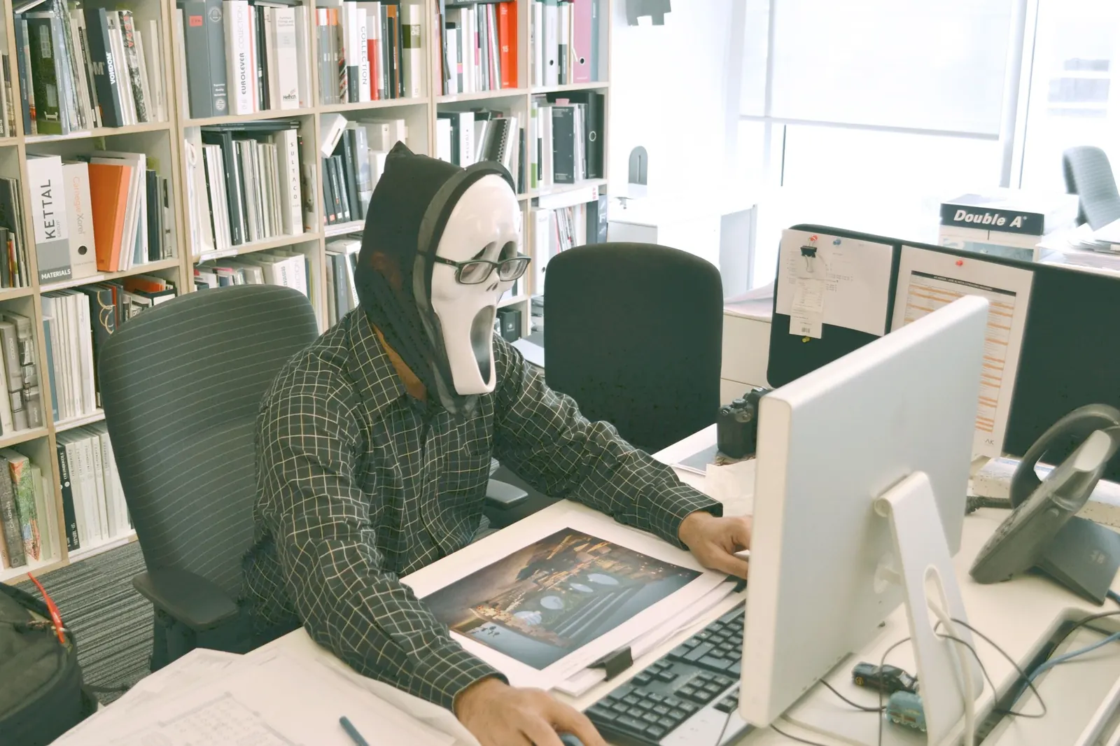 Persona con máscara de fantasma frente a una computadora